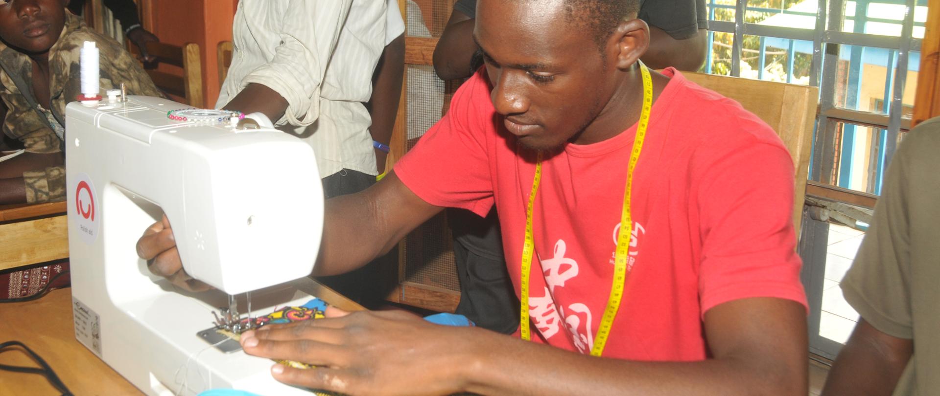 Kampala, Uganda. 17th, December, 2018. Mugweri Christopher learning to operating a tailoring machine during a tailoring class at the Children's Charity Academy in Muyenga. The Embassy of the Republic of Poland in Nairobi donated the tailoring machine to the Academy.