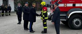 nadbryg. Adam Koneczny – Zastępca Komendanta Głównego Państwowej Straży Pożarnej gratuluje przedstawicielowi OSP Branków