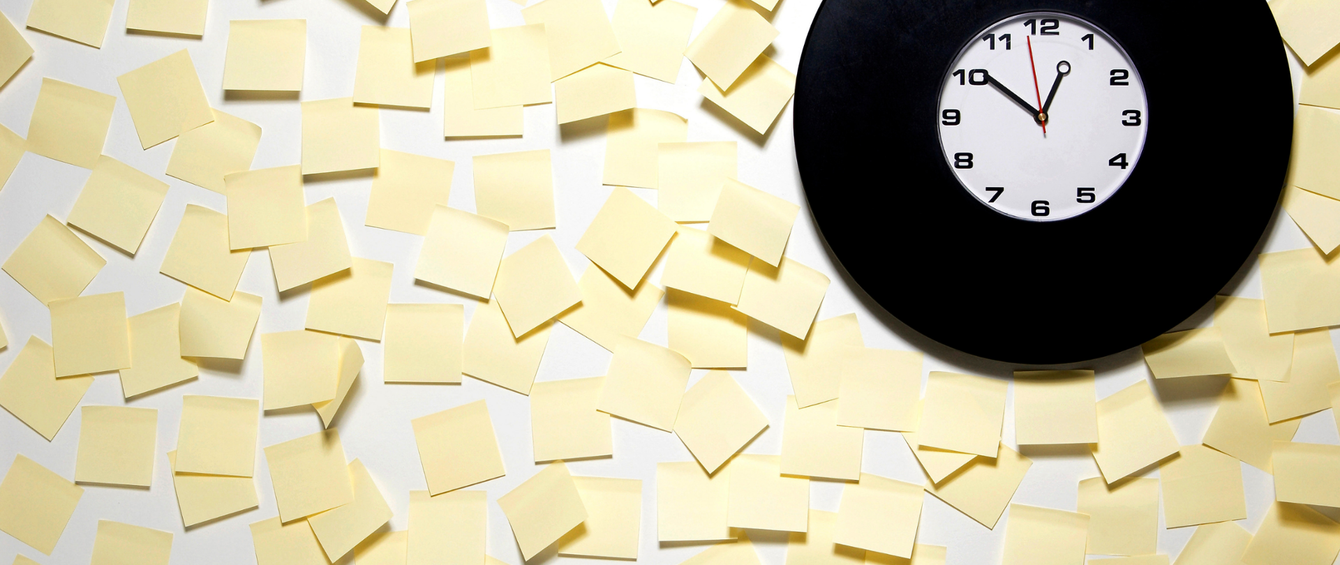 Żółte karteczki na ścianie oraz zegar