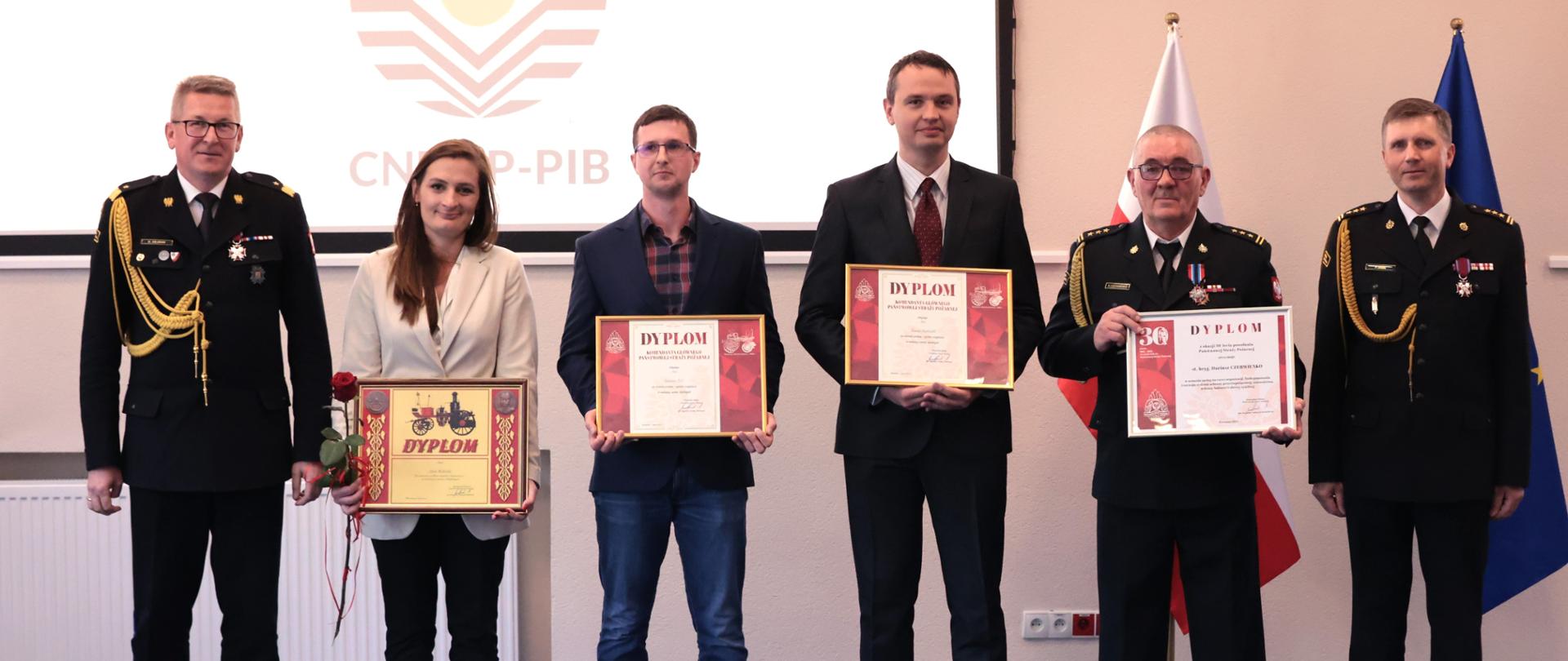 Wspólne zdjęcie pracowników cywilnych i funckjonariuszy którzy otrzymali dyplom komendanta głównego PSP 