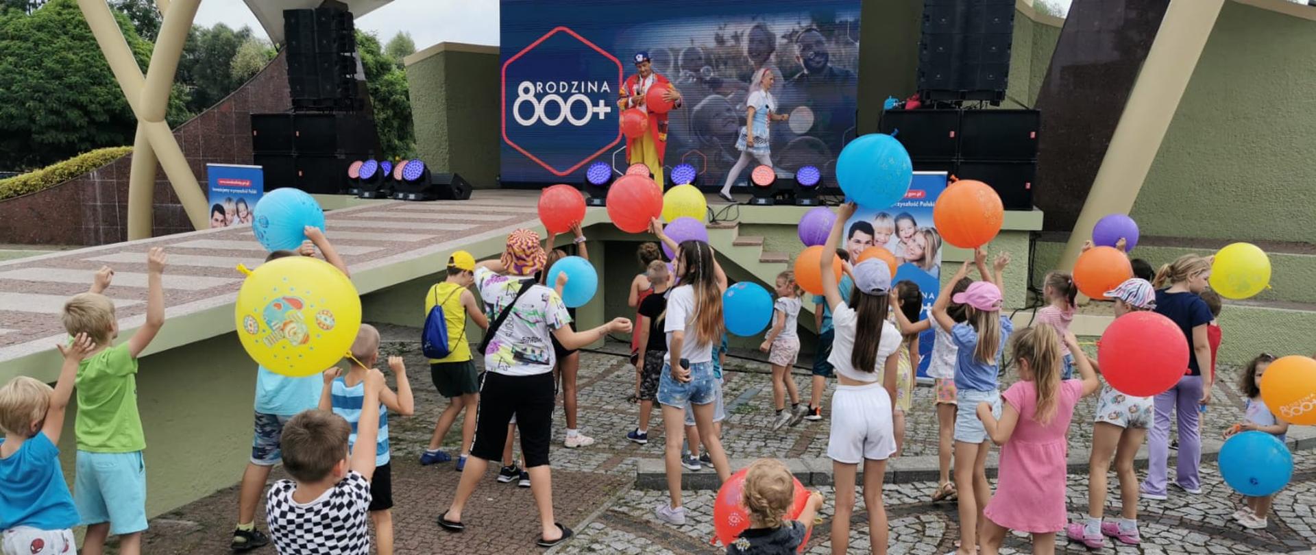 Dzieci bawią się pod sceną na Pikniku 800+ w Ełku 