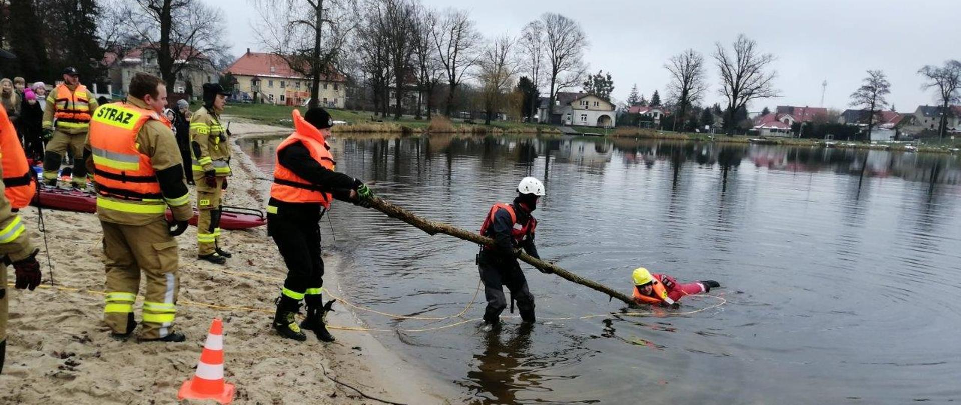 Akacja „Bezpieczne ferie 2023” - strażacy wyciągają tonącego trzymającego sie gałęzi