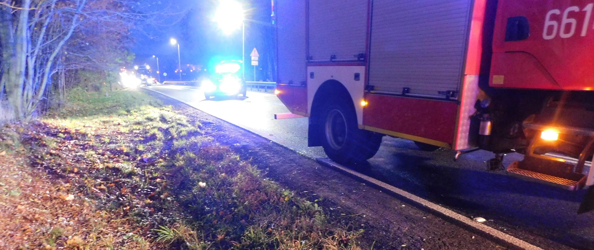 Na zdjęciu samochód strażacki a w przydrożnym rowie oderwane koło samochodu