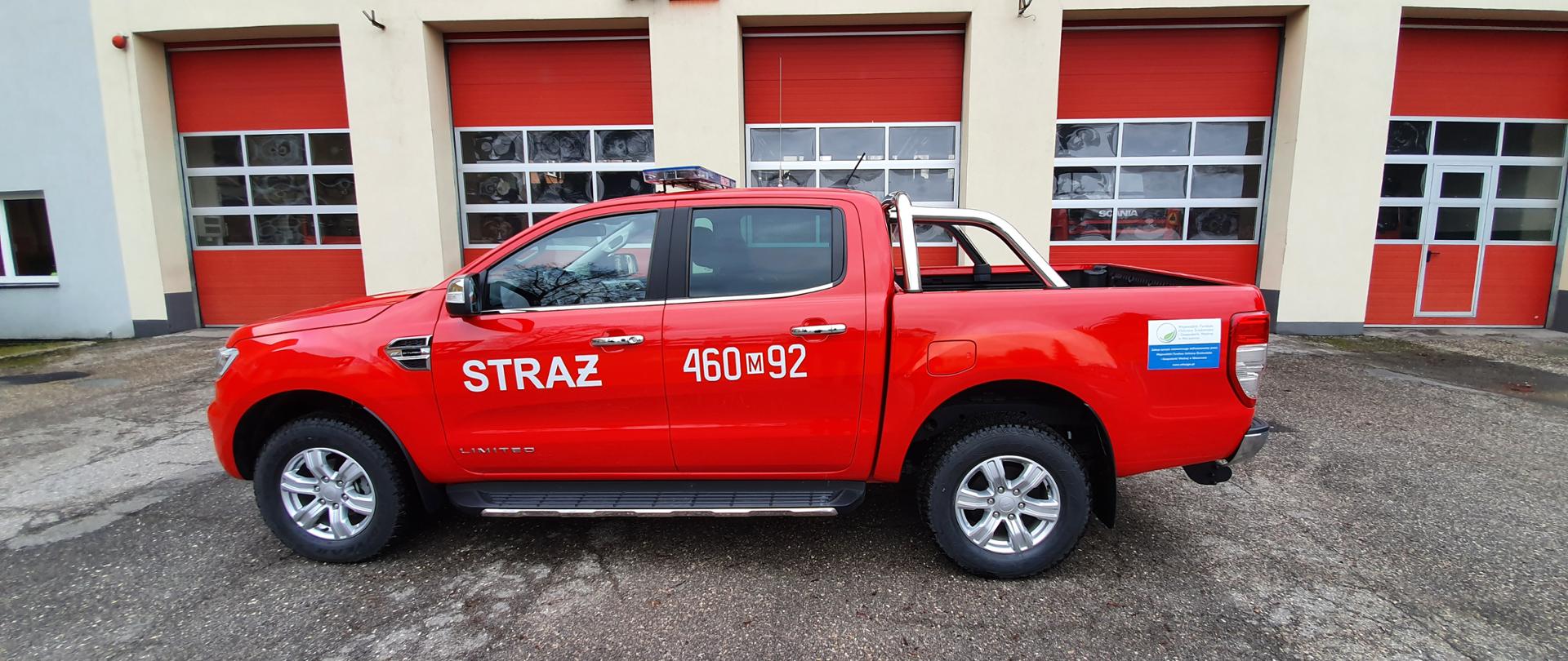 samochód osobowy Ford Ranger w kolorze czerwonym na tle bram garażowych Komendy