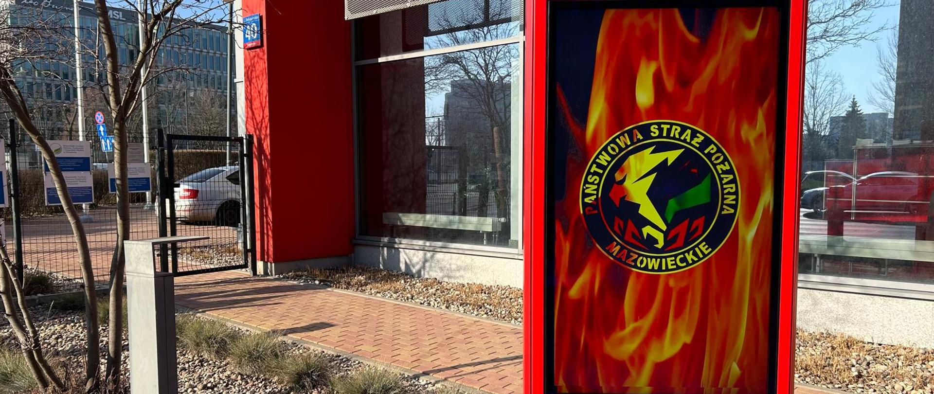 Widok zewnętrznego ekranu informacyjnego, zainstalowanego przed wejściem do budynku KW PSP w Warszawie