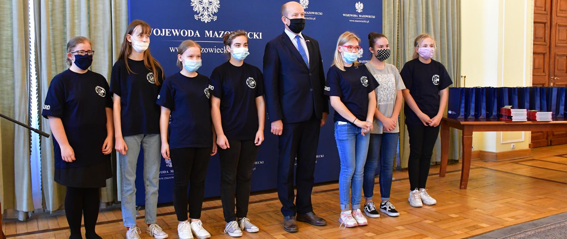 Wojewoda Mazowiecki podczas wspólnego zdjęcia z siedmiorgiem podopiecznych Instytutu Głuchoniemych w Warszawie.