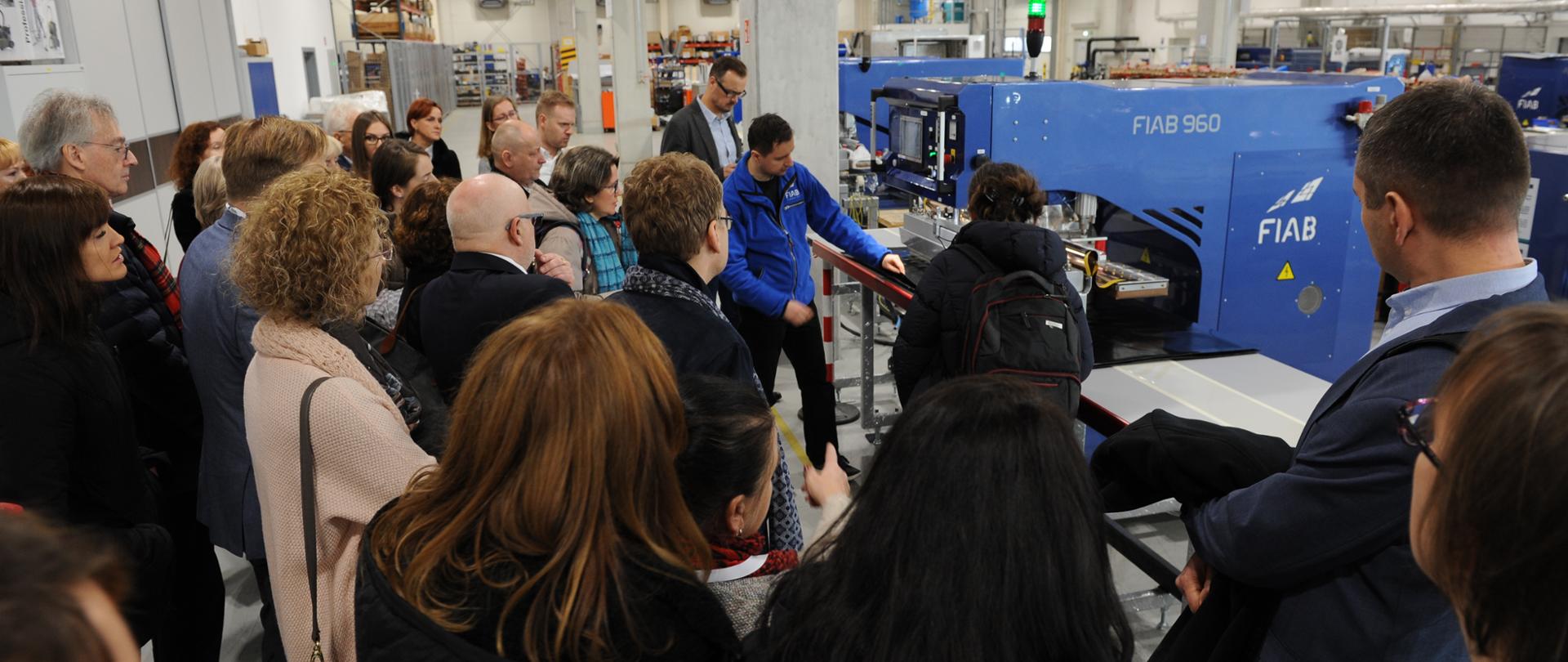 Kilkanaście osób w hali przemysłowej