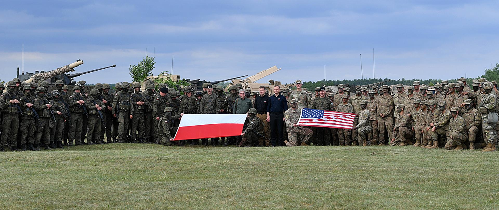 Polish President and Polish Minister of Defence group picture with Polish and USA soldiers, Polish and US flags showed