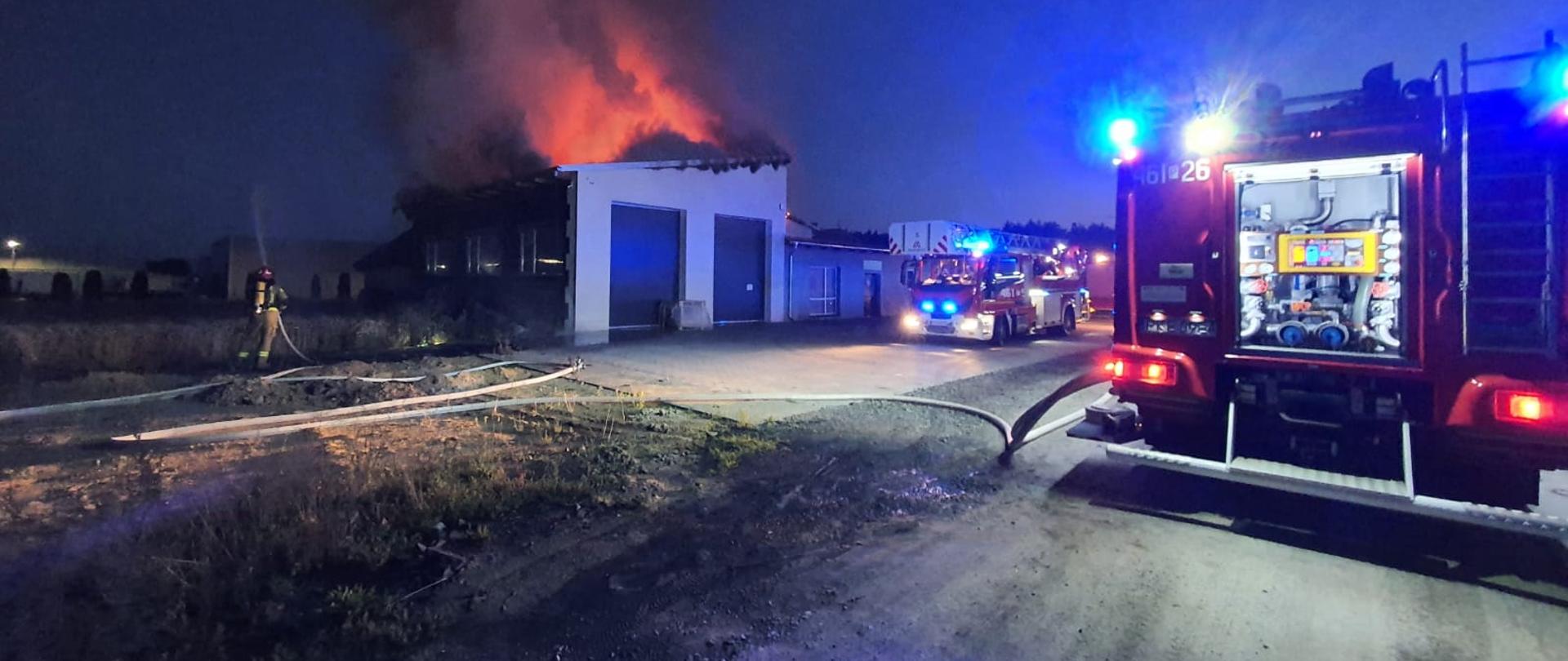 Strażacy gaszący pożar budynku magazynowego.