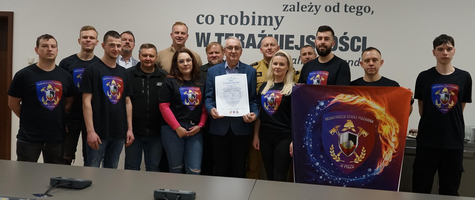 Strażacy pozujący do zdjęcia.
