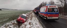 Na zdjęciu znajdują się pojazdy pożarnicze, ZRM ustawione wzdłuż drogi oraz samochód osobowy znajdujący się w rowie