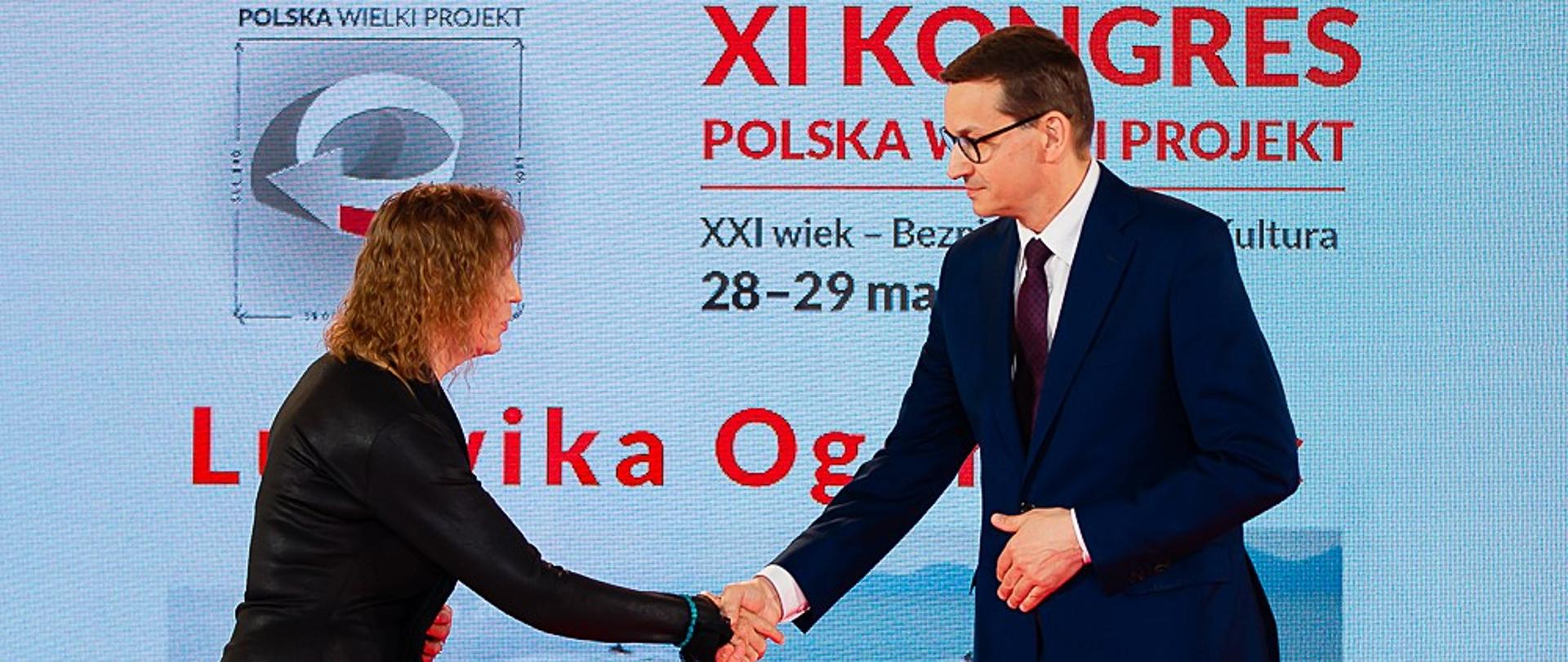 Premier Mateusz Morawiecki podaję rękę laureatce.