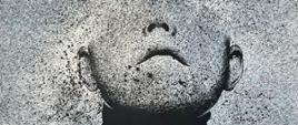 Czarno-biały portret półpiersia osoby (ramiona i twarz do górnego poziomu uszu, oczy już niewidoczne)
