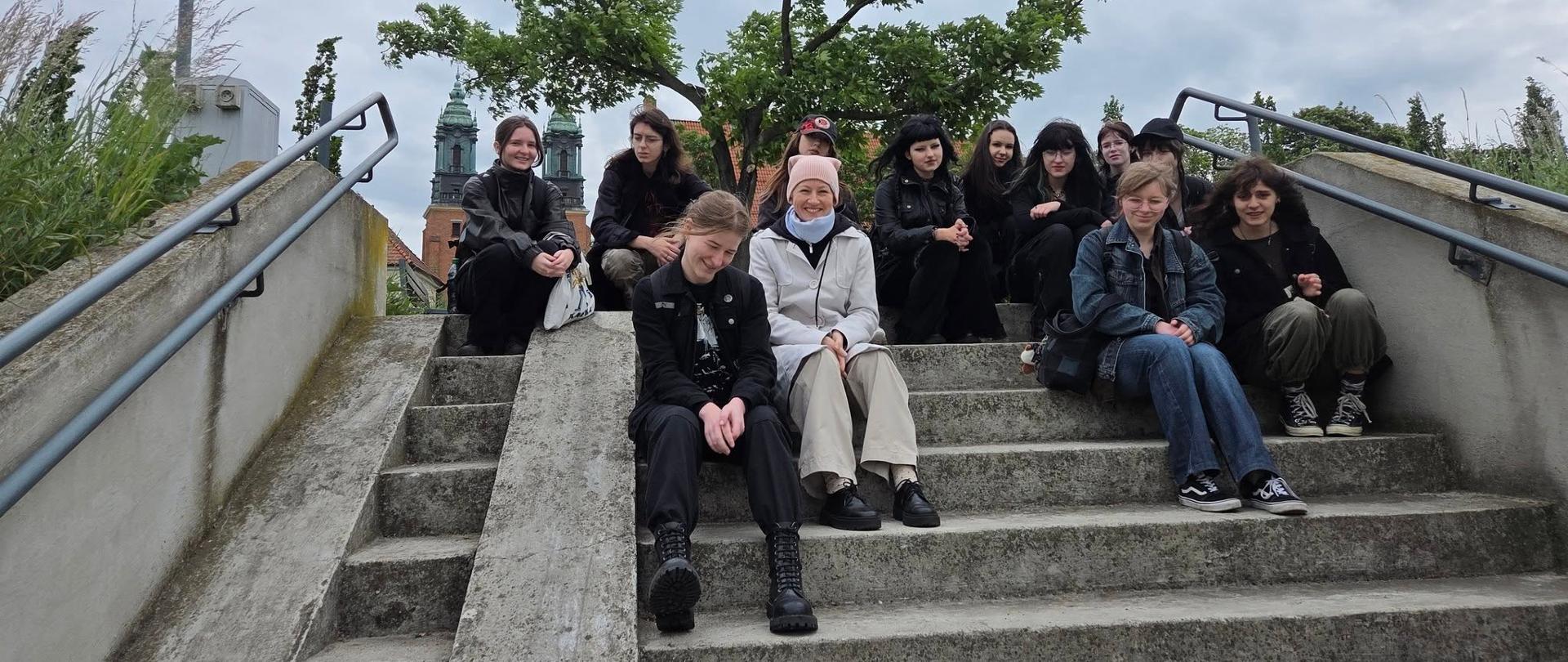 Grupa młodzieży siedzi na schodach