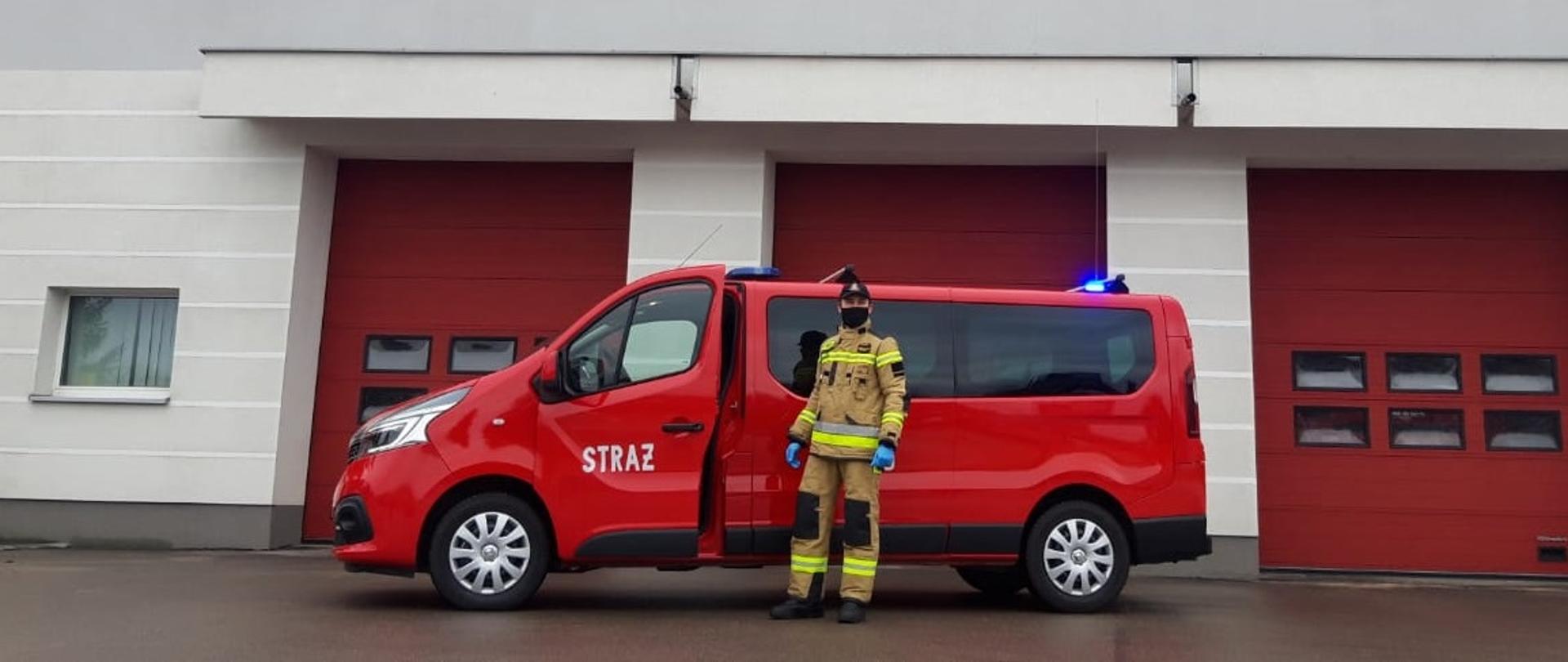 strazak psp przy samochodzie renault trafic w tle budynek komendy Państwowej Straży Pożarnej w Nowym Mieście Lubawskim 