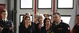 Komendant powiatowy z mównicy przemawia do strażaków i zaproszonych gości w tle pracownicy komendy