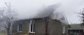 Wybuch gazu w budynku mieszkalnym, budynek murowany kryty eternitem, uszkodzony szczyt budynku, zadymione poddasze, uszkodzone ściany boczne budynku, gruz na posesji z uszkodzonego szczytu