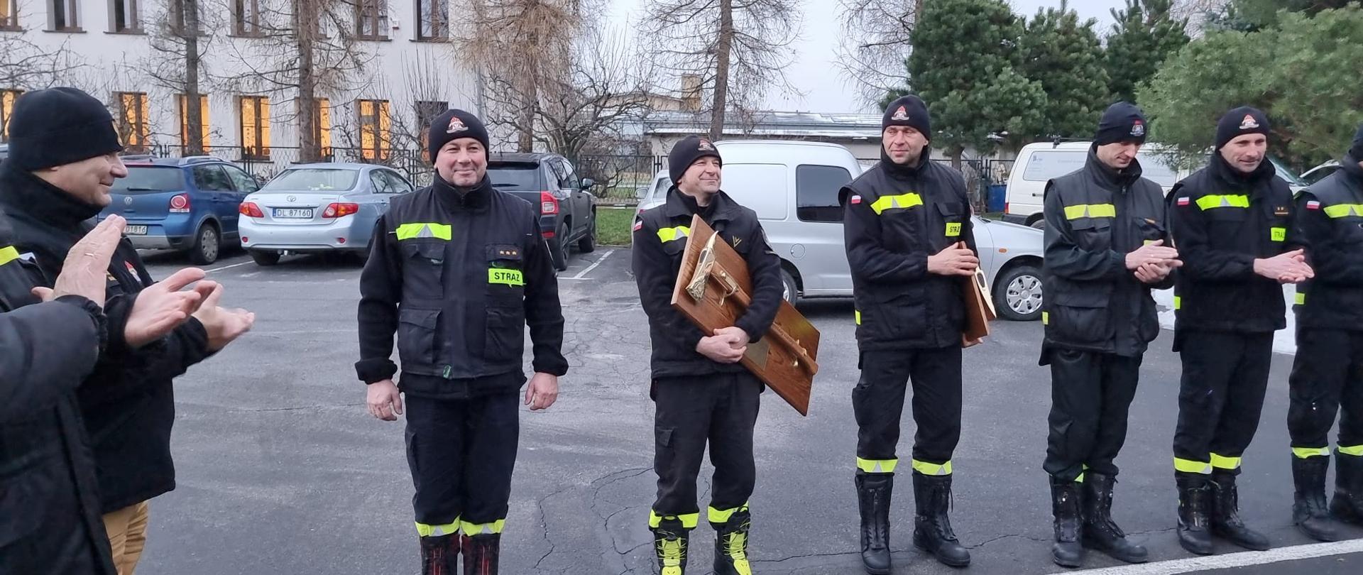 Obraz przedstawia strażaków podczas zmiany służby