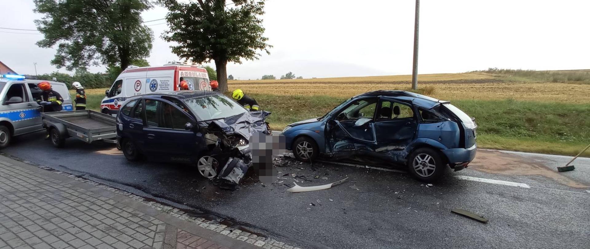 Na drodze krajowej nr 22 stoją dwa samochody osobowe po zderzeniu czołowo-bocznym.