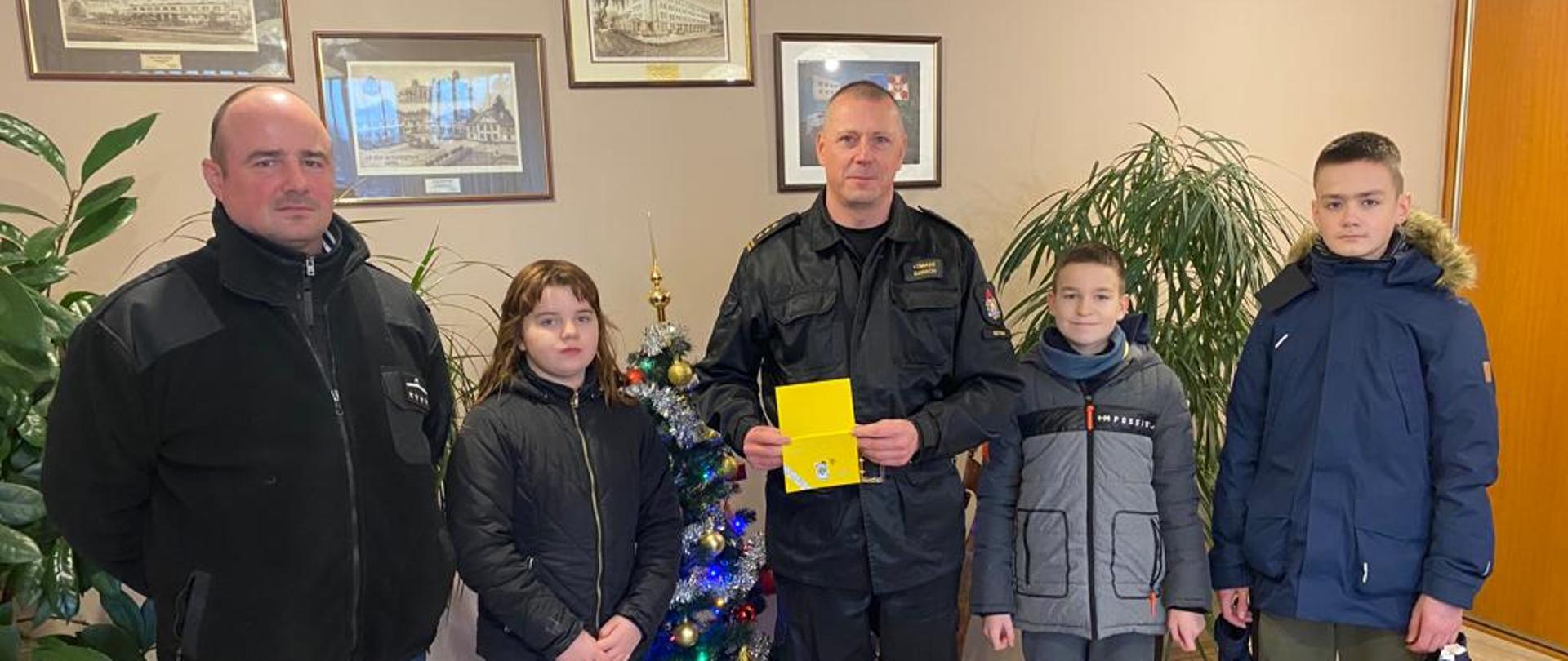 w gabinecie komendanta stoją komendant opiekun mdp oraz młodzi druhowie