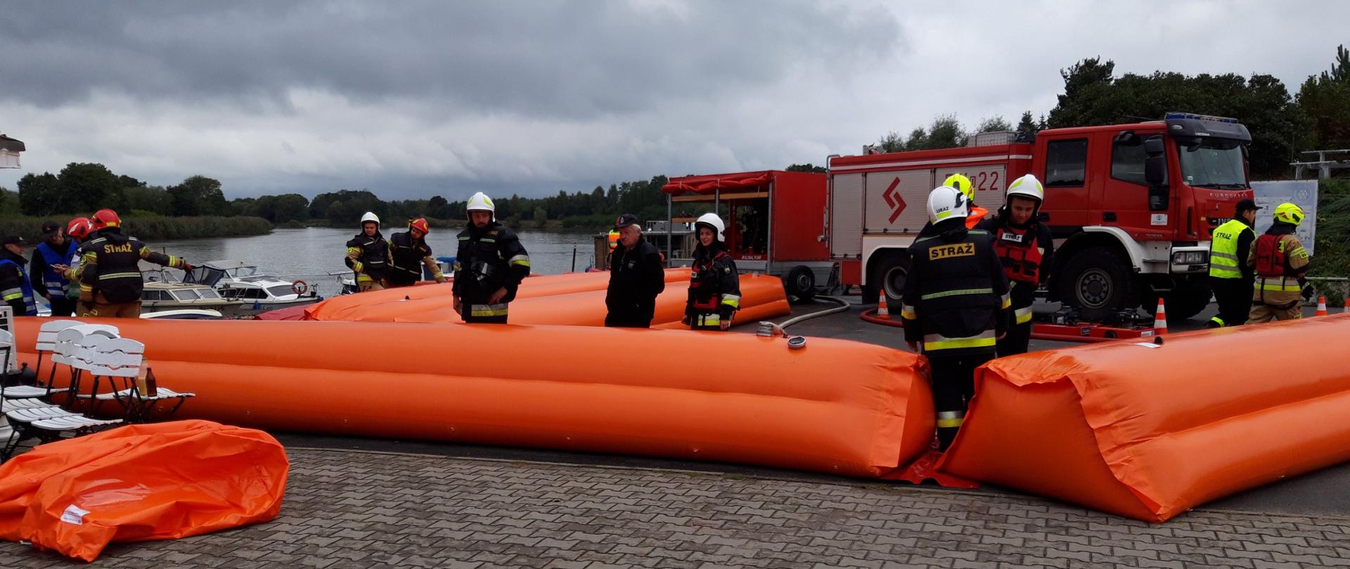 Strażacy rozkładają przeciwpowodziową zaporę