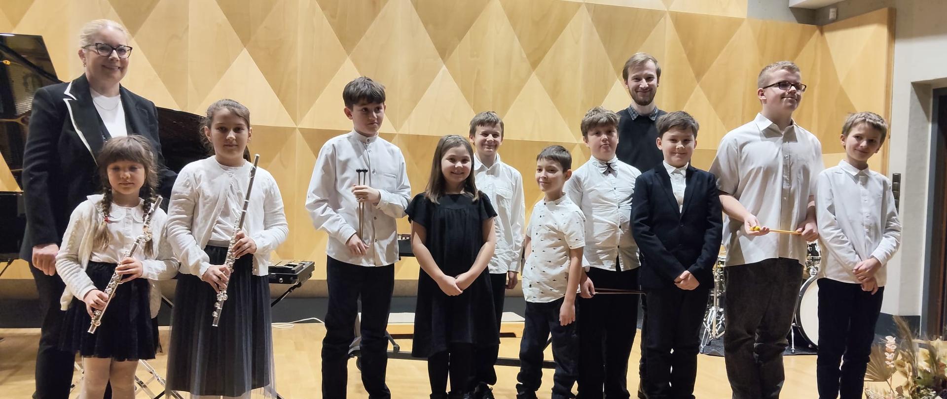 Grupa uczniów na scenie saki koncertowej PSM