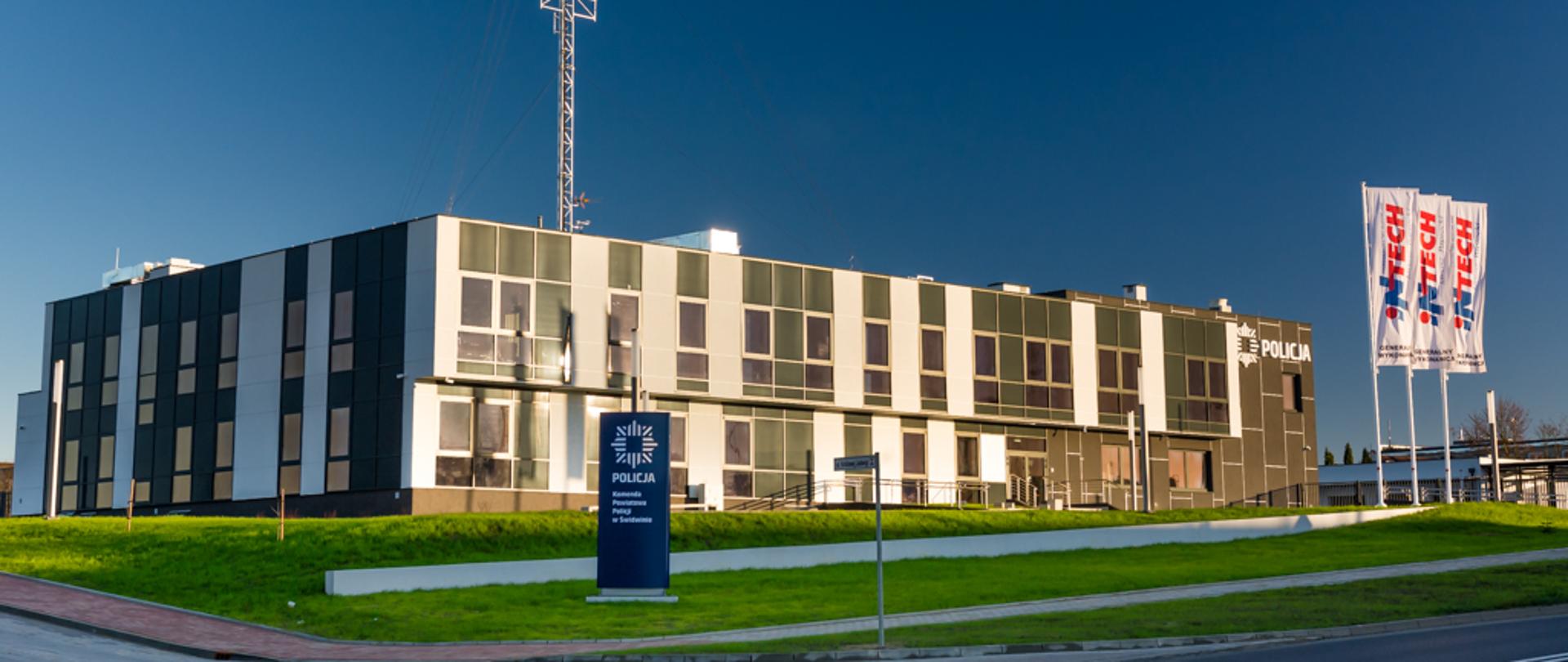 Zdjęcie przedstawia nowy nowoczesny budynek Komendy Powiatowej Policji w Świdwinie. Na budynku widzimy maszt antenowy.
