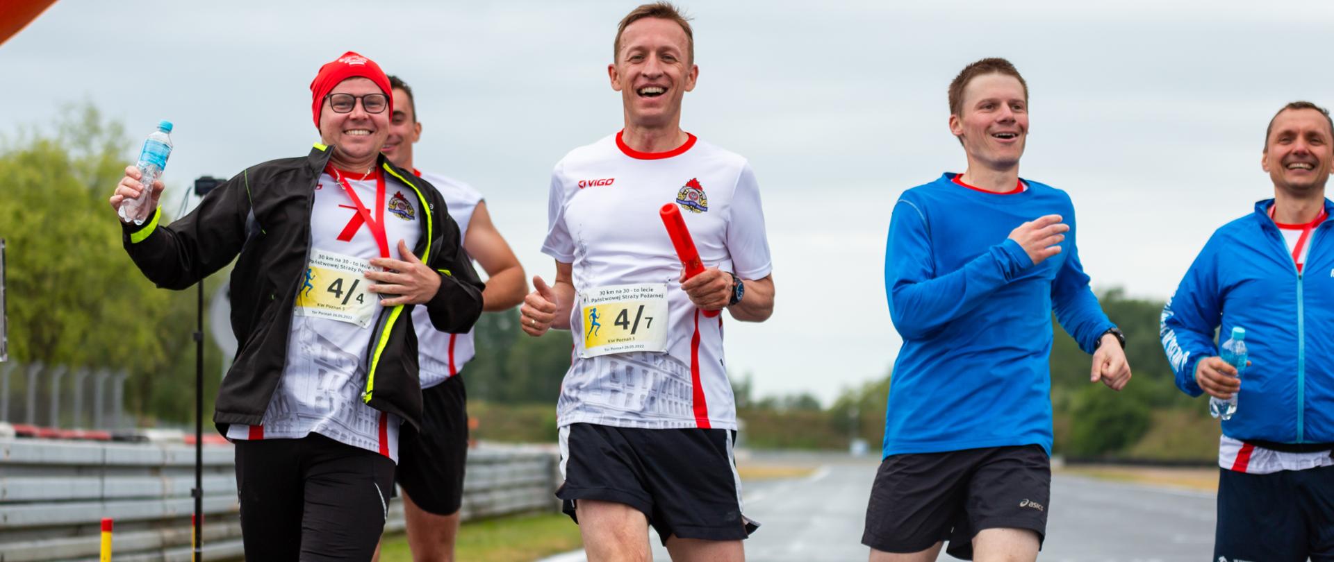 Na zdjęciu widać mężczyzn którzy kończą bieg na mecie. 