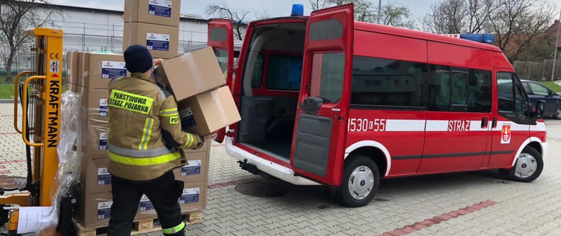 Mężczyzna wkłada pudełka kartonowe do samochodu. 