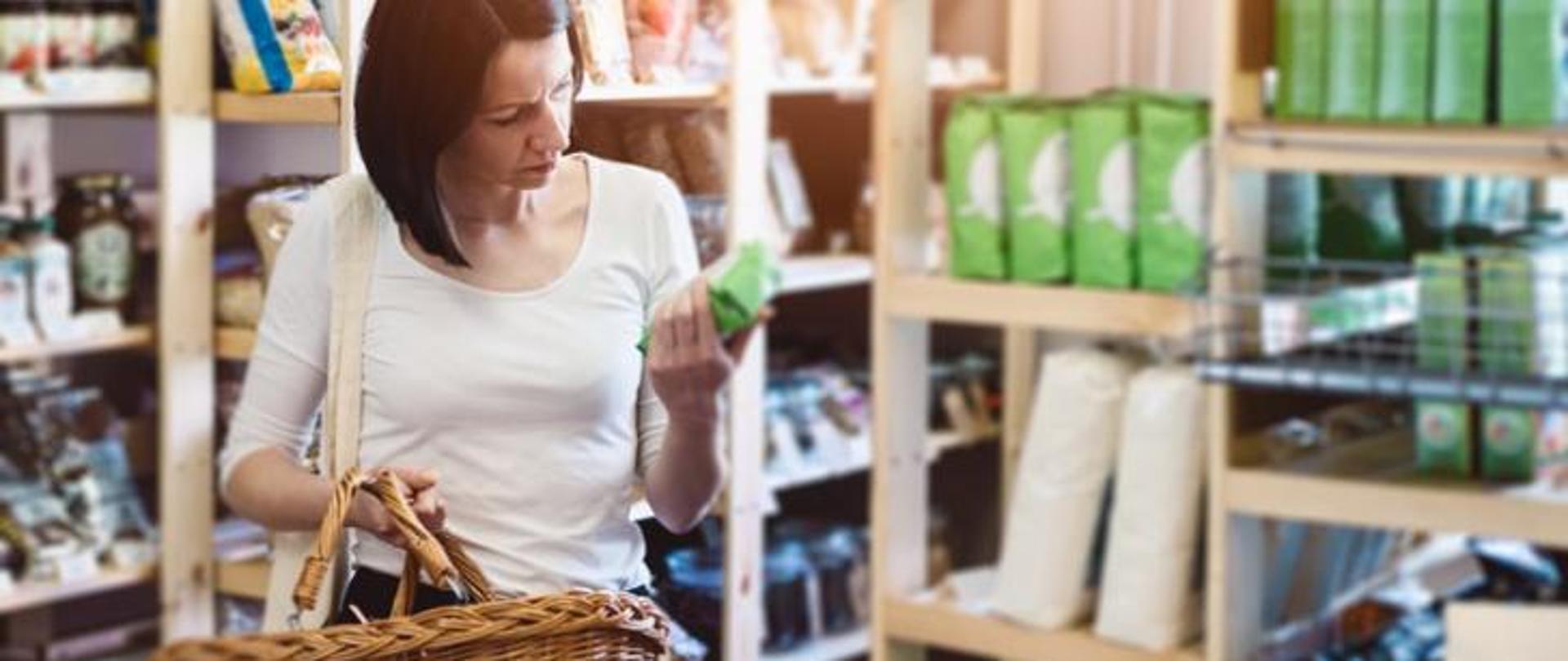 Kobieta czyta etykietę produktu w sklepie