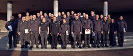 Pamiątkowe zdjęcie grupowe funkcjonariuszy i dwóch funkcjonariuszek Służby Więziennej (29 osób) będących uczestnikami szkolenia inspektorów ochrony przeciwpożarowej w towarzystwie Zastępcy Komendanta Centralnej Szkoły PSP, kobiety oraz dwóch funkcjonariuszy CS PSP