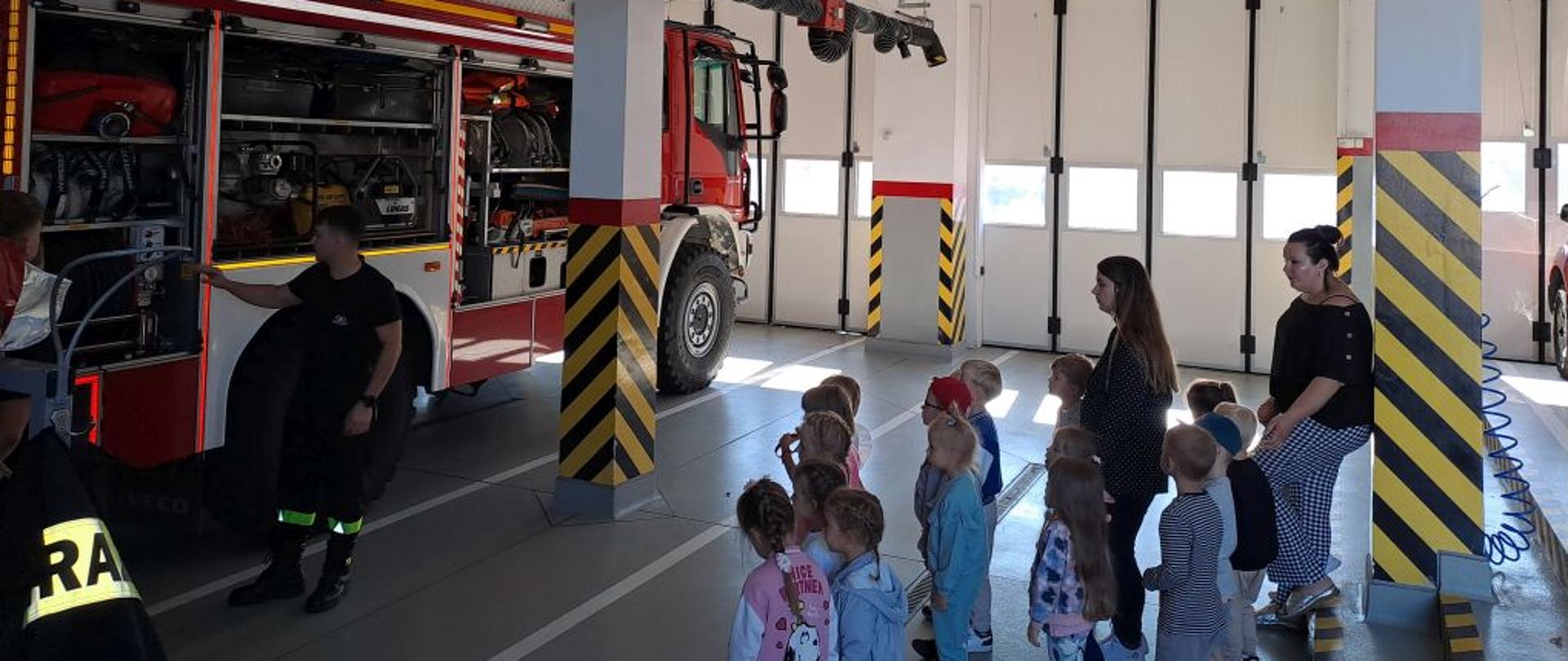 Na zdjęciu widać dzieci podczas wizyty w strażnicy Państwowej Straży Pożarnej.