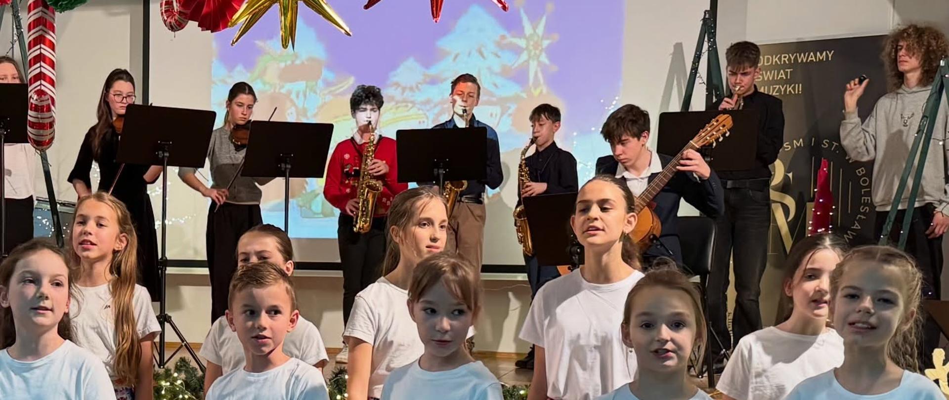 Zdjęcie przedstawiające uczestników koncertu świątecznego - spotkania z kolędą, które odbyło się 18 grudnia 2025 r. w auli szkoły.