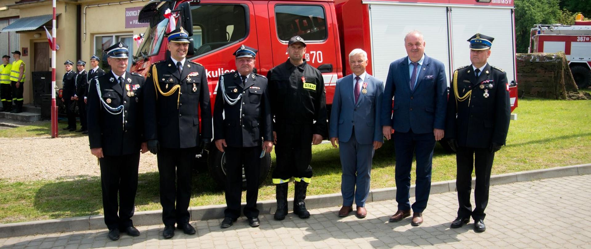 Na zdjęciu na tle samochodu pożarniczego zaproszeni na uroczystość wymienieni w artykule goście 