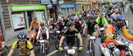 Zdjęcie przedstawia rowerzystów maratonu MTB podczas przejazdu ulicami miasta.