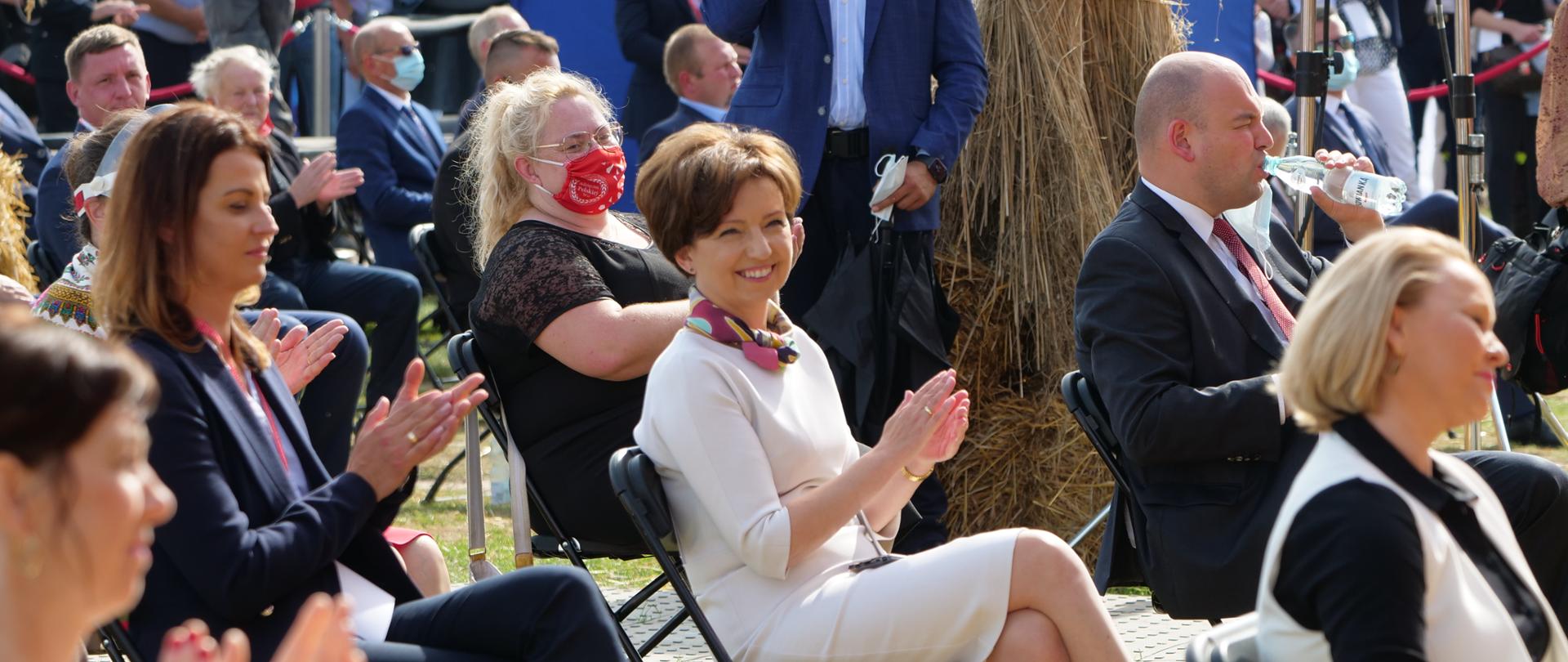 Piknik i Dożynki w Bralinie. Minister Marlena Maląg siedzi wśród publicnzości.