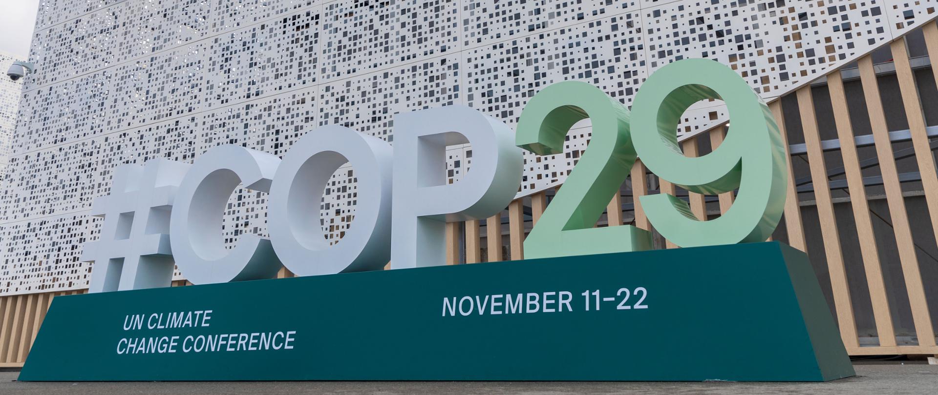 Jeden z pawilonów z logotypami UNFCCC i COP29 w Baku. Na pierwszym planie napis #COP29.