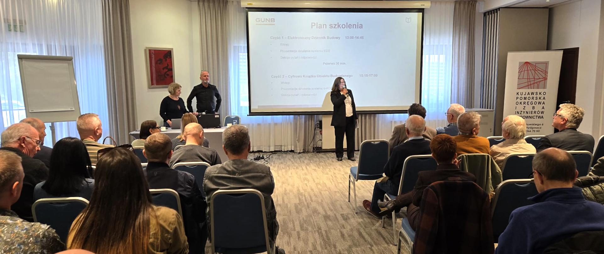 Na zdjęciu sala szkoleniowa – uczestnicy siedzą, słuchają prelegenta.