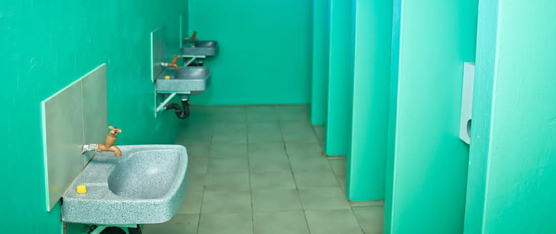 wyremontowana łazienka w kolorze zielonym. czyste pomieszczenie z umywalkami