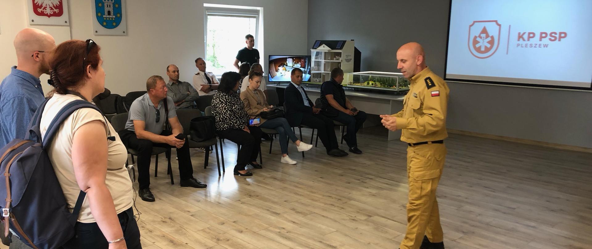 Strażak opowiadający zainteresowanym o pracy w straży pożarnej