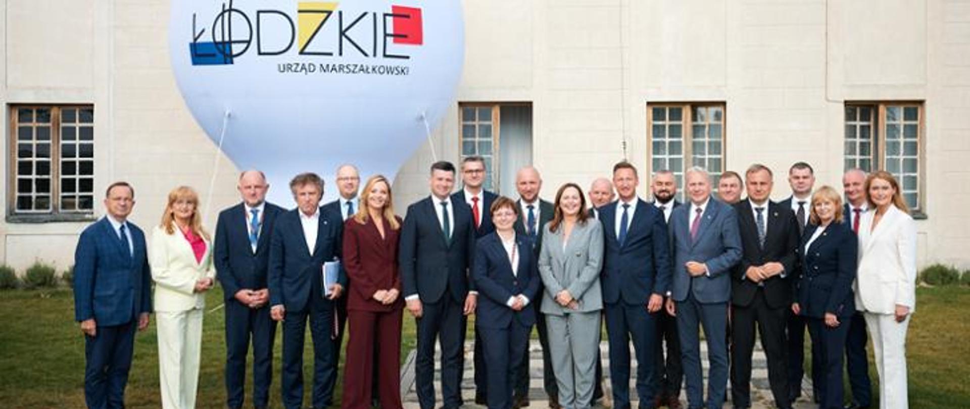The photo shows Deputy Minister Jacek Karnowski with other meeting participants. A balloon with the Łódź city logo is visible in the background.