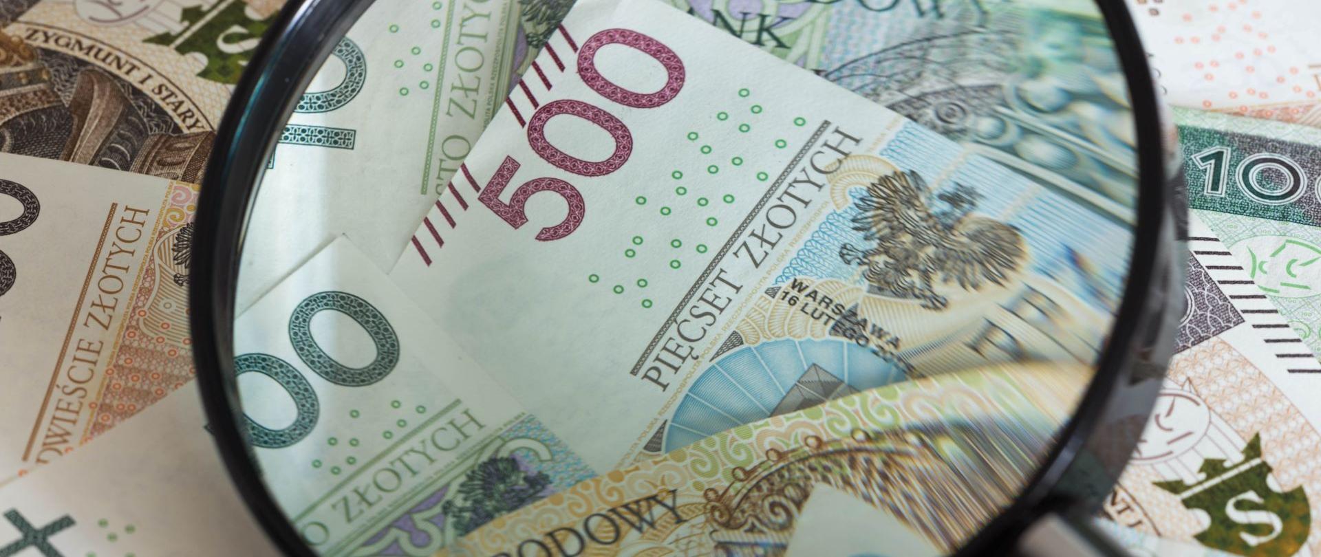 Banknoty pod szlem powiększającym.