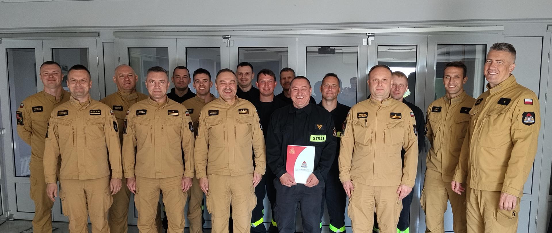 Na zdjęciu Komendanci Miejscy wraz ze zmianą służbową podczas wręczenia pochwały strażakowi