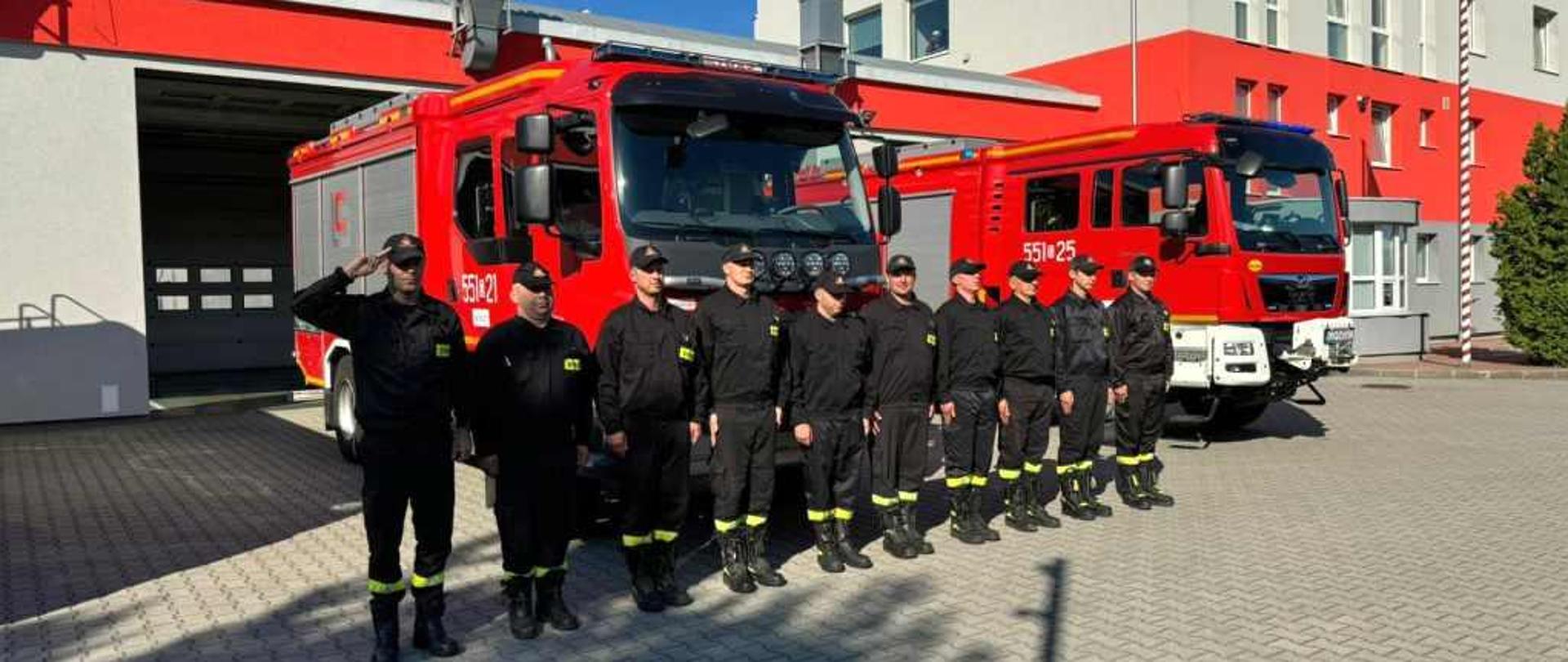 Rocznica Wybuchu Powstanie Warszawskiego obchodzona przez strażaków na tle budynku i wozów strażackich