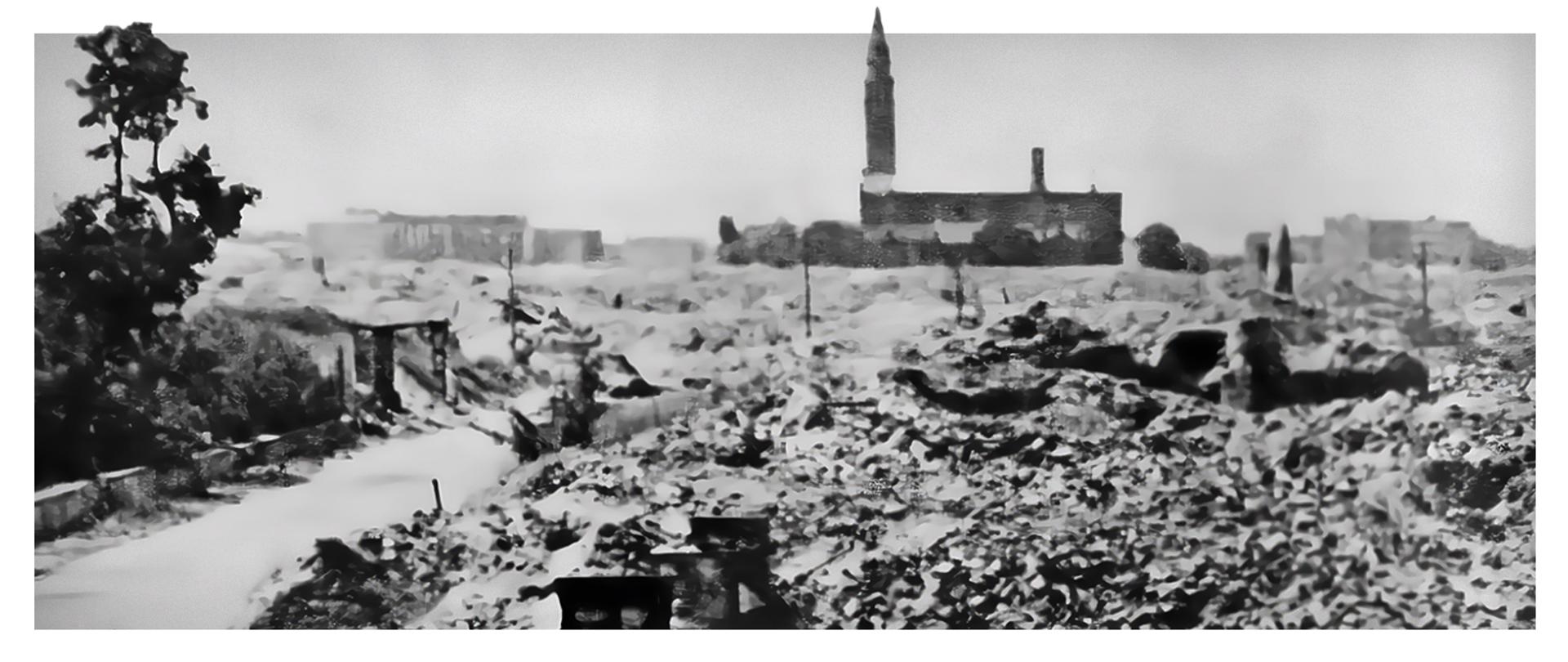 czarnobiała fotografia ruin miasta z zarysem kościoła w tle