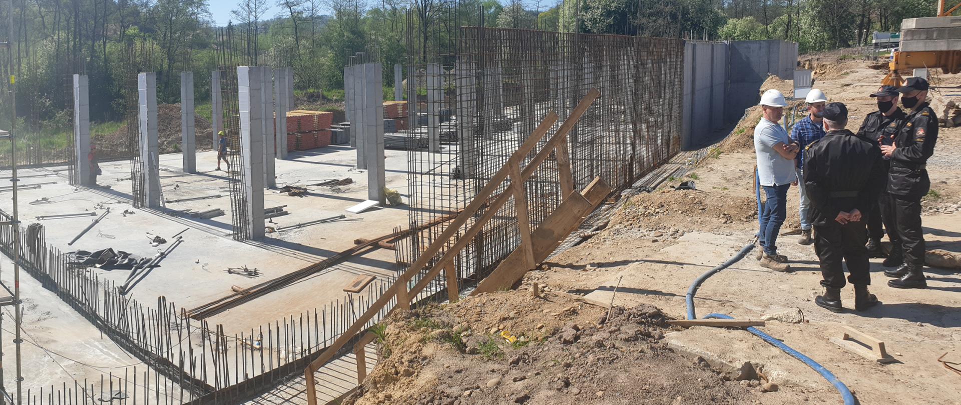 Na zdjęciu małopolski komendant wojewódzki PSP mł. bryg. Przemysław Przęczek, komendant powiatowy PSP w Wieliczce mł. bryg. Leszek Kasiński oraz przedstawiciele wykonawcy inwestycji na terenie budowy Komendy Powiatowej PSP w Wieliczce