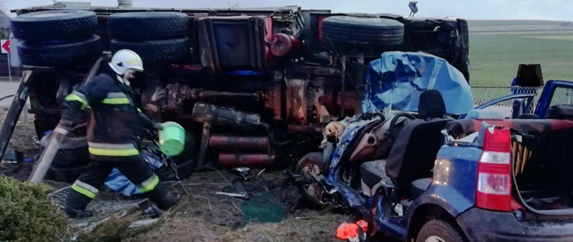 Na zdjęciu wraki pojazdu ciężarowego oraz samochodu osobowego w kolorze niebieskim