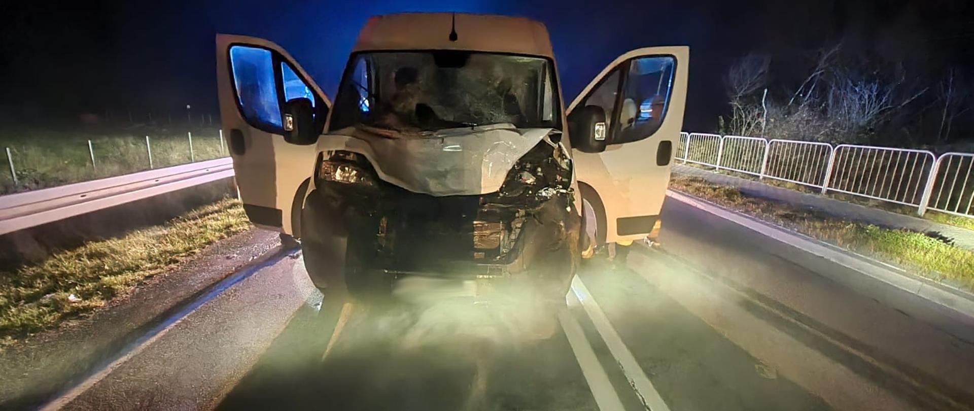 Rozbity samochód typu bus na drodze.