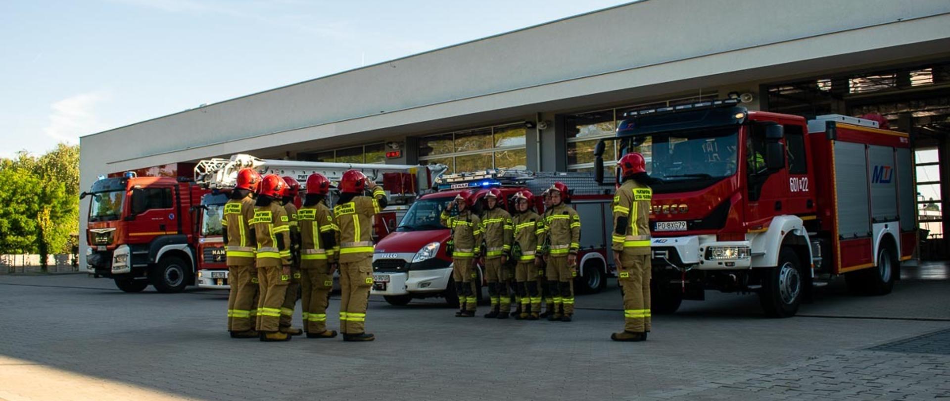 Na zdjęciu strażacy JRG Śrem podczas uroczystej zmiany służby oddający hołd zmarłemu strażakowi KG PSP przed garaże wyjechały samochody ratowniczo - gaśnicze i specjalne 