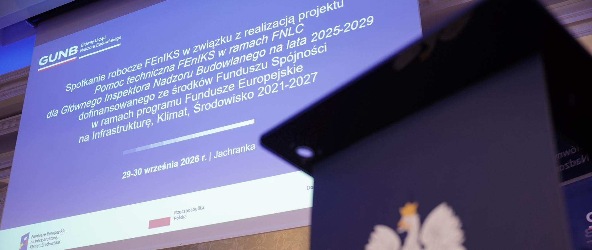 Mówca wygłasza przemówienie na konferencji, stojąc przy mównicy przed publicznością.